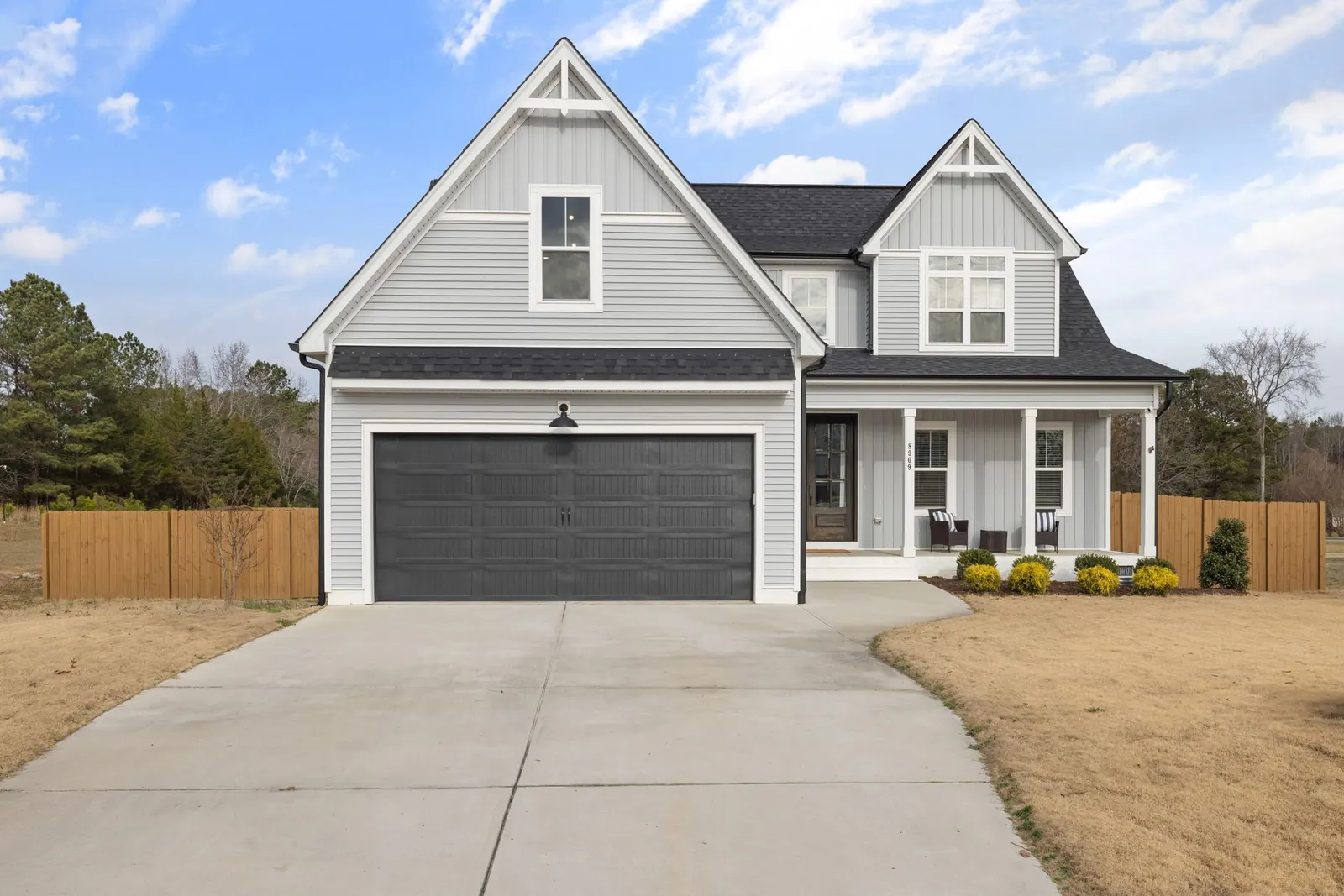 A white farmhouse with a detached garage