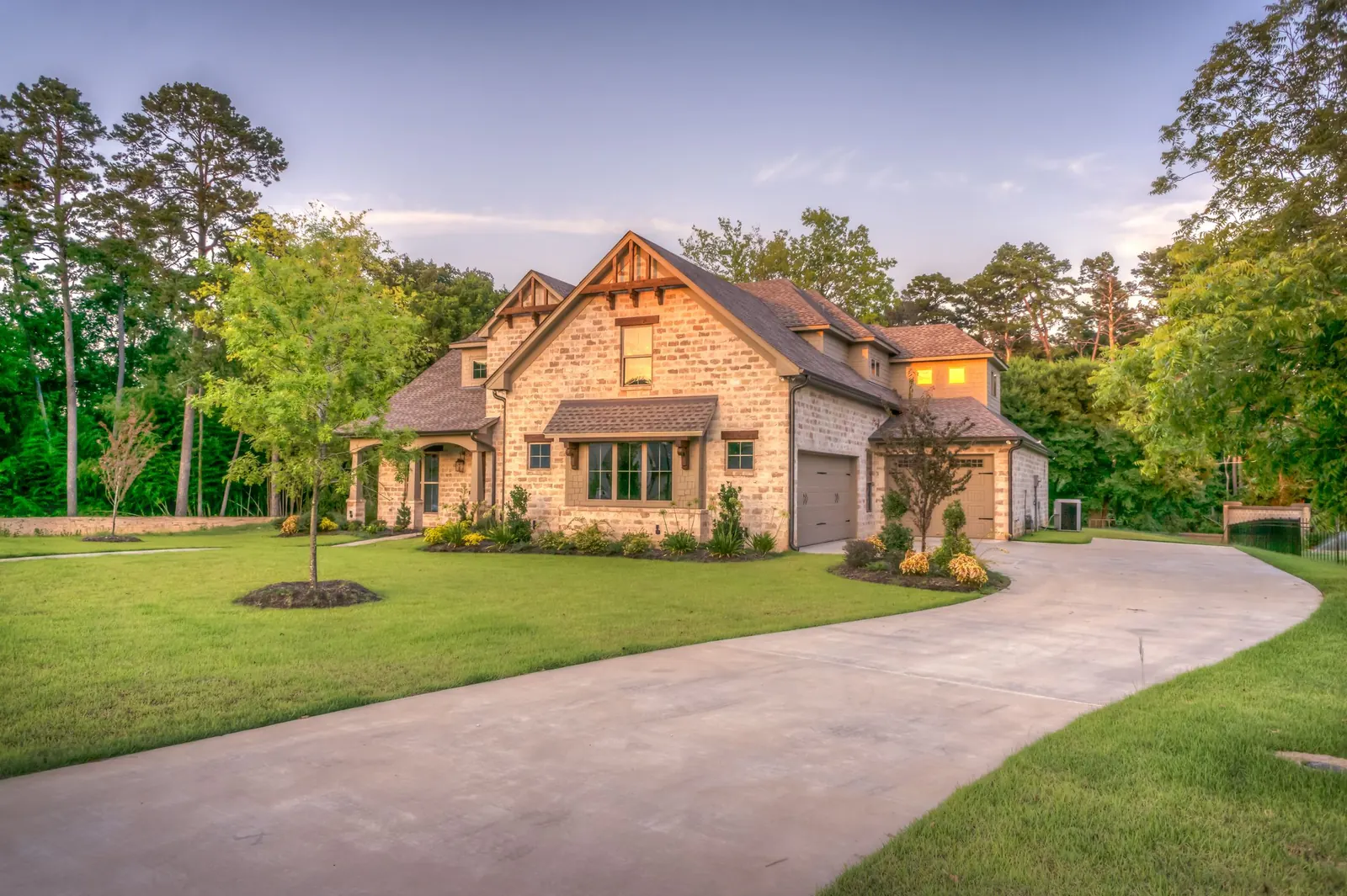 A stone and shingle house with a landscaped front yard