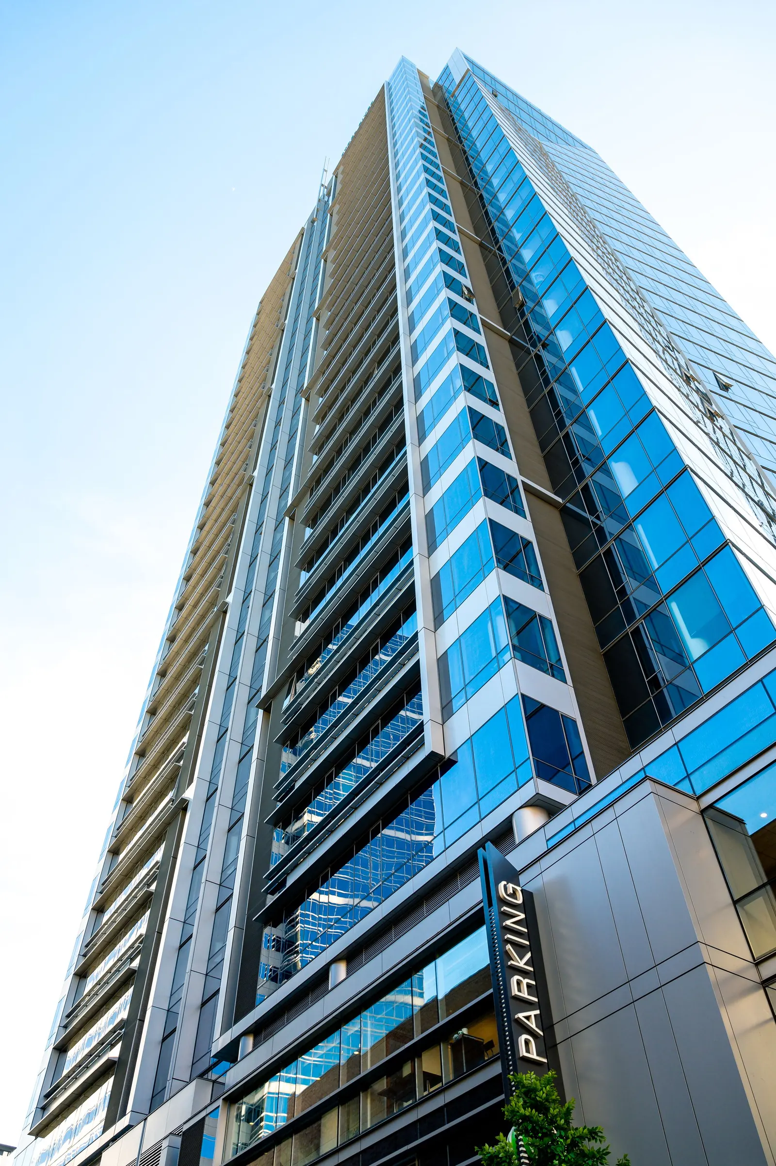 A curved glass tower photographed from below