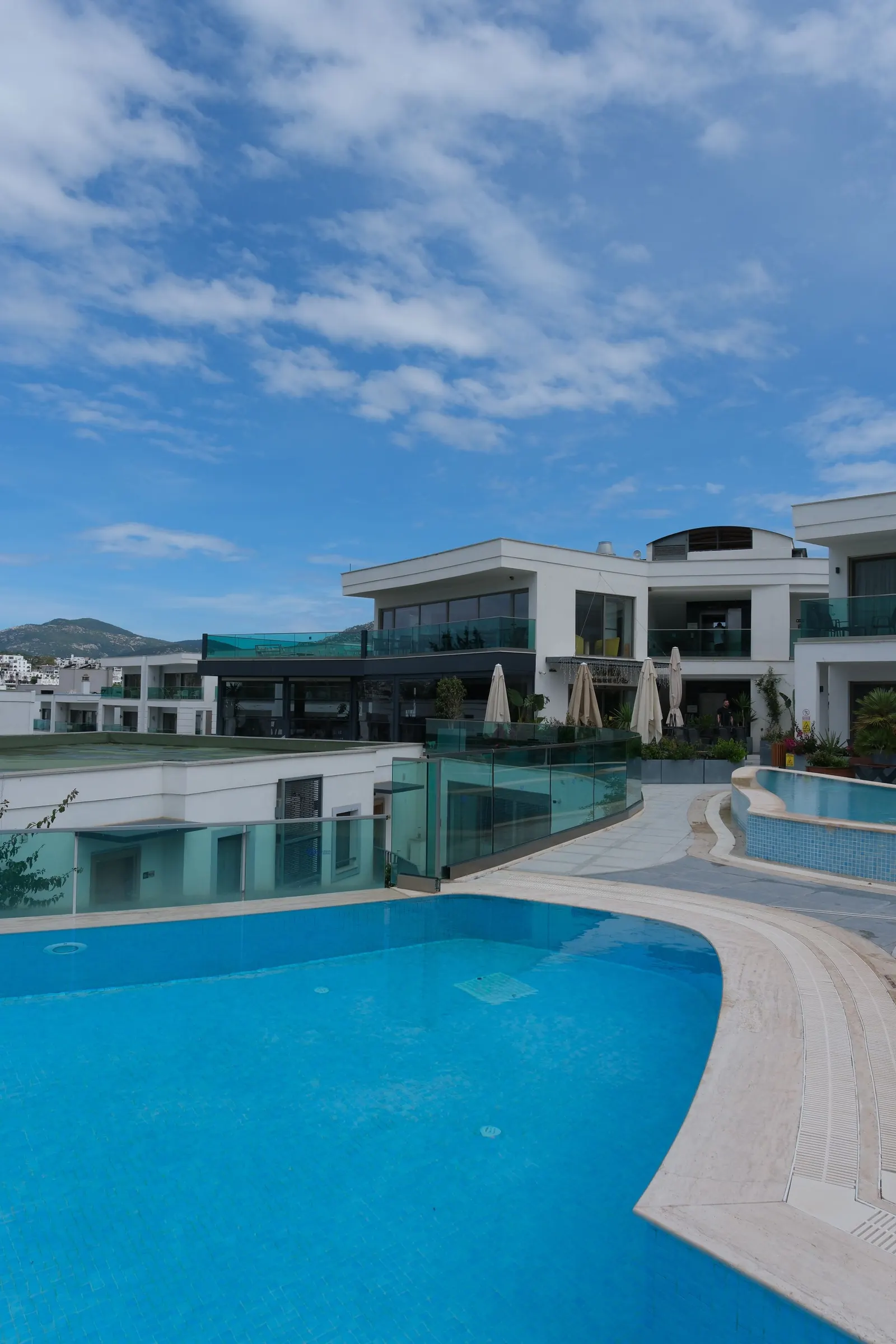 A swimming pool reflecting a white modern villa